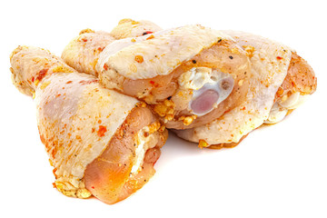 Marinated with spices chicken drumsticks isolated on white background with reflection on glossy surface