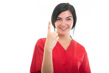 Portrait of young attractive female nurse showing number one