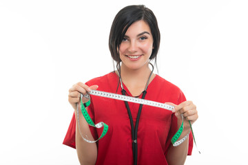 Portrait of young attractive female nurse showing measuring tape