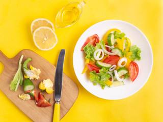 Salad of fresh vegetables on a yellow background. Vegan, vegetarian.