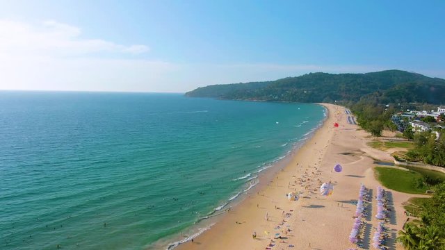 Aerial 4k view flying over tropical blue ocean towards beautiful green mountains and white sandy beach