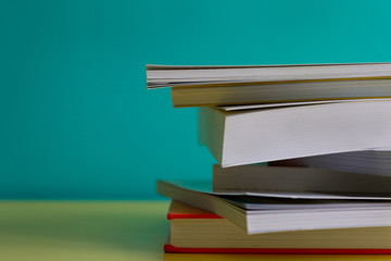 Pile of books in a colorful desk (concept knowledge)