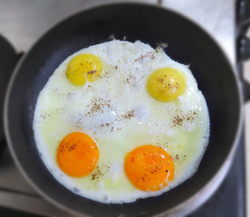fried eggs in a frying pan, sunny side up