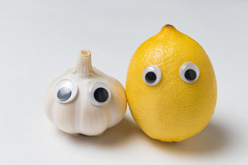 Lemon and garlic with Googly eyes and funny faces. Health foods concept