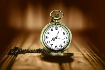 Vintage pocket watch on a wooden background. Selective focus