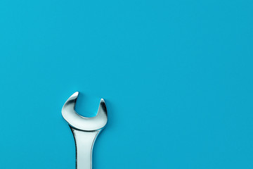 Wrench on a blue background copy space top view. Service concept.