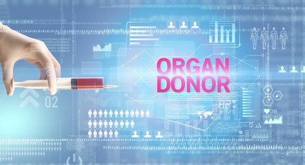 Close-up view of doctor's hand in a white glove holding syringe with ORGAN DONOR inscription, healthcare and medical concept