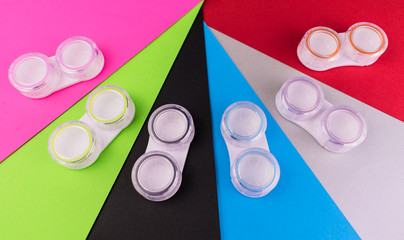 
Containers for soft contact lenses, on a colorful background. Containers for cleaning and storing...