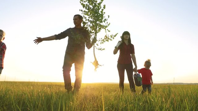 agriculture red neck farming happy family walking agriculture of farmers a silhouette concept slow motion video. mom dad lifestyle son and daughter walk go children happy family plant and water the