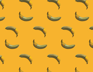 Seamless texture of bananas wearing condom on a yellow background with hard shadows