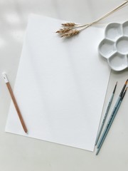 Styled stock photo. Mockup blank sheet layout with brushes and palette, and white background.