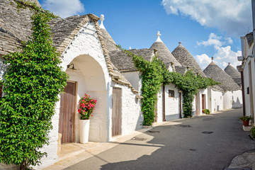 Fototapeta na wymiar Trulli of Alberobello, Puglia, Italy: Typical houses built with dry stone walls and conical roofs. In a beautiful sunny day.