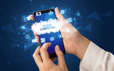Female hand holding smartphone with CLOUD COMPUTING inscription, cloud technology concept