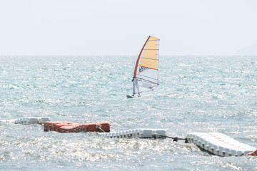 The sailboat player is racing on the sea. As another popular water sports.