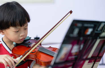 boy plays violin on blur note foreground ,selective focus