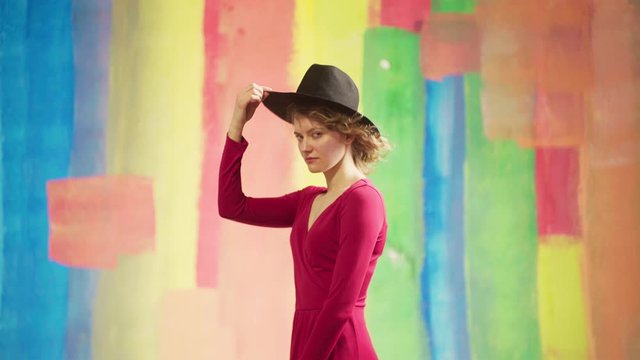 Young beautiful woman standing over colorful background very happy and excited smiling and screaming for success. Fashionable Pin-up girl.