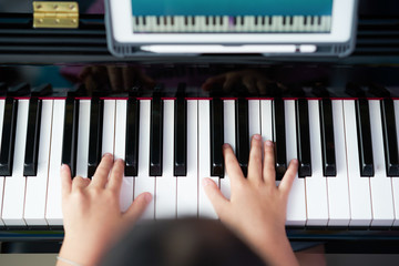 Fototapeta premium hands play piano in class education with tablet in home online learning in covid-19 crisis quarantine