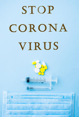 Yellow pills, capsules, tablets, syringe and needle on blue background with copyspace. Stop coronavirus concept. Protect yourself.