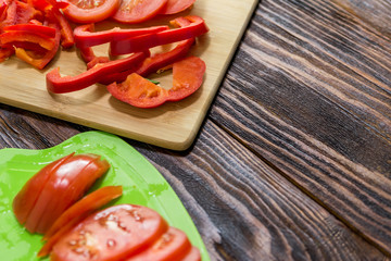 sliced red tomatoes and peppers on a sliced Board. red vegetables, vitamins from the garden