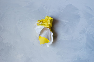 Fototapeta na wymiar Yellow torn and crumpled paper on a gray background
