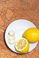 Natural vitamins. Lemon and garlic on a wooden background. Homemade medicine.