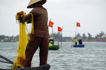 vietnamese fisherman fishing with net