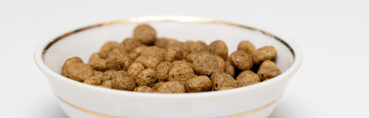 Balls of cat food in a beautiful bowl on a white background