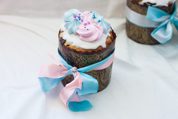 Traditional slavic orthodox easter cake named kulich with white icing, meringue decoration and festive ribbons