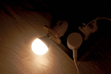 The led bulb is lit plugged into the socket. Electrical appliances and devices consume electricity. Energy Economics.