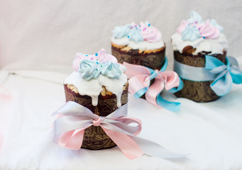 Traditional slavic orthodox easter cake named kulich with white icing, meringue decoration and festive ribbons