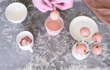 The pastry chef makes dessert on a stick. Cake pops. Chocolate cream for dessert, creation process.