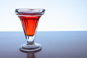Copa con jugo color rojo con iluminación trasera