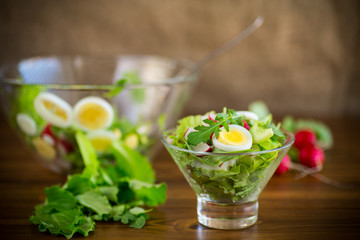 spring salad with arugula, boiled eggs, fresh radish, salad leaves in a glass bowl