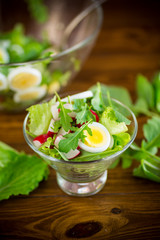 spring salad with arugula, boiled eggs, fresh radish, salad leaves in a glass bowl