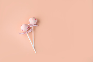 Composition of cake pops on a light background with a different cream. Dessert on a stick.