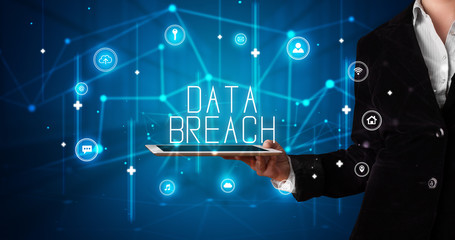 Young business person working on tablet and shows the digital sign: DATA BREACH