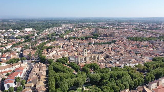 Scenic panoramic aerial view of residential areas of Narbonne with medieval Roman Catholic Cathedral on sunny summer day, France