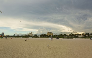 Fototapeta na wymiar Beautiful landscape view of sunset Miami South Beach coast line. Sand beach, Atlantic Ocean, people on blue sky background. USA. Miami Beach. 