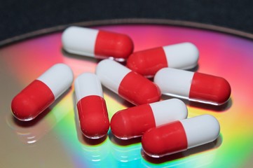 White and red capsules on rainbow background