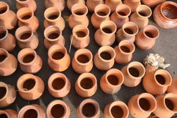 Rows of unglazed clay pottery jars, jugs and pots for cooking without lids.