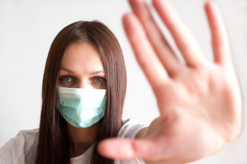 Stop coronavirus. Young white woman wearing face mask. White background