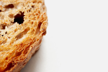 Macro photo of the texture of fresh wheat bread, a little toasted. On a white background.