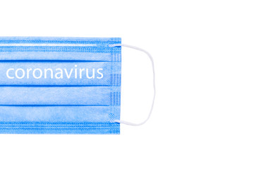 blue medical mask located on the left isolated on a white background. on the mask is the...