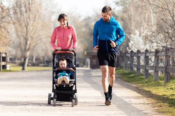 Sporty young couple with her little son running while enjoying the time together outdoor.