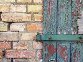 Background texture old door with green broken paint and a yellow brick wall