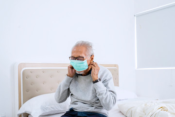 Senior man wearing mask on the bed