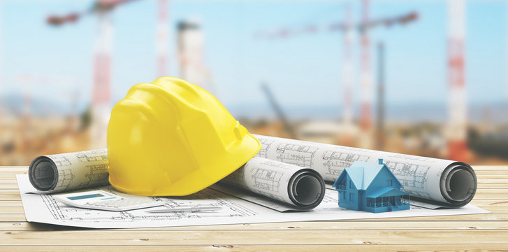 Close-up Of Yellow Hardhat Amidst Blueprints On Table At Construction Site