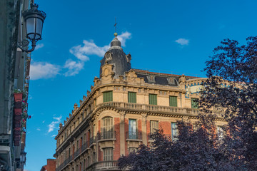 Fototapeta na wymiar Old library building in Pamplona in Navarra, Spain, located in Plaza San Francisco, with a red brick facade with a blue mosaic in the center, two blue tile domes on the sides stone balconies and trees