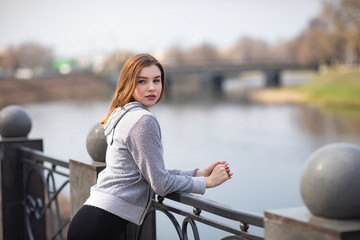 Young woman standing on a bench in the park