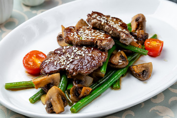 medallions of beef with mushrooms on white plate